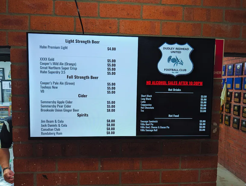 Outdoor digital menu screen showing club drink and food prices