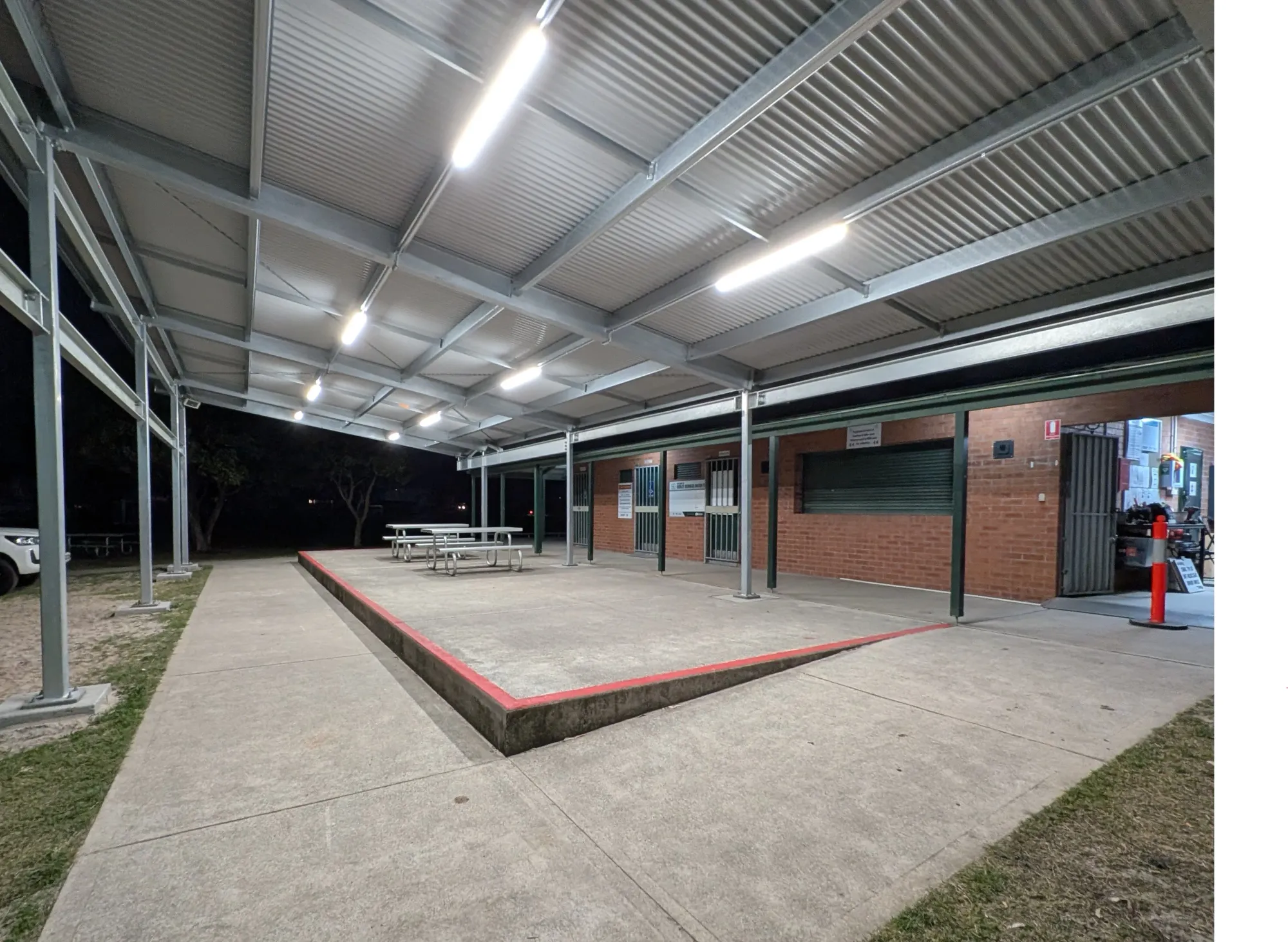 Covered outdoor courtyard lit by ceiling LED strip lighting at night