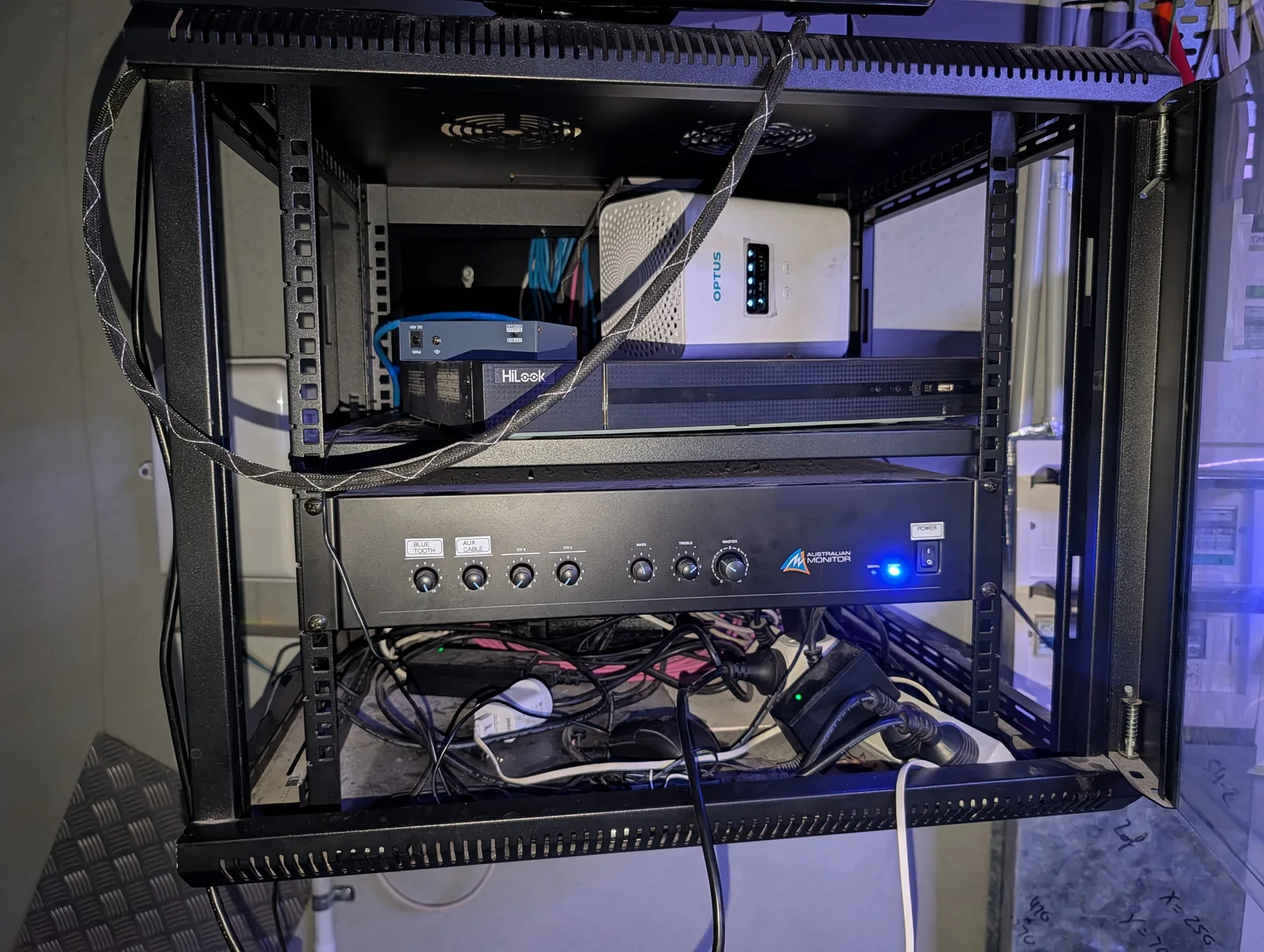 Comms cabinet before the clean-up, with loose and unlabelled cabling