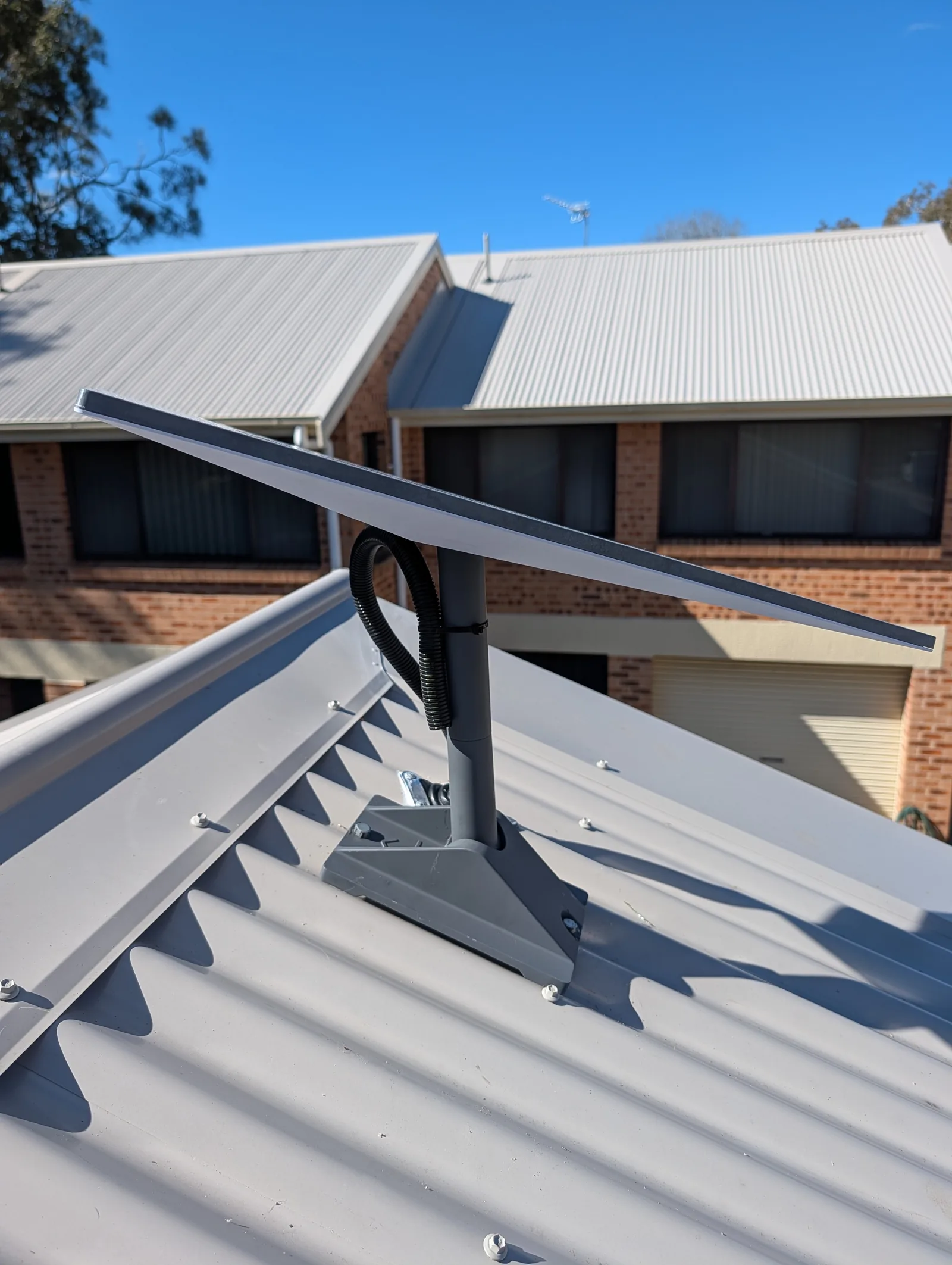 Starlink dish on a bracket fixed to a metal roof